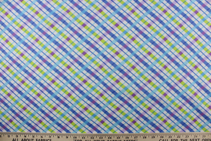 This quilting print features a diagonal plaid design in blue, purple, lime green, and a light blue against a white background. 