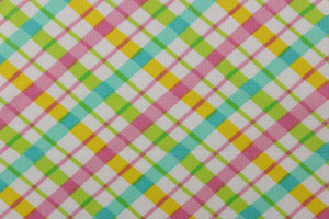  This quilting print features a diagonal plaid design in yellow, pink, green, and a pale teal blue against a white background.