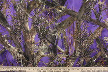 Load image into Gallery viewer, This camo fabric features realistic branches and leaves in varying shades of brown, gray, white and black against a purple background. 
