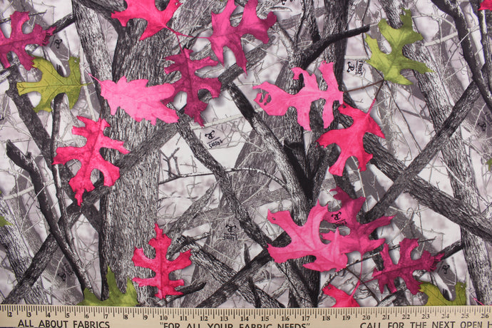  This camo fabric features realistic branches and leaves in gray, green, hot pink and black against a gray and white background. 