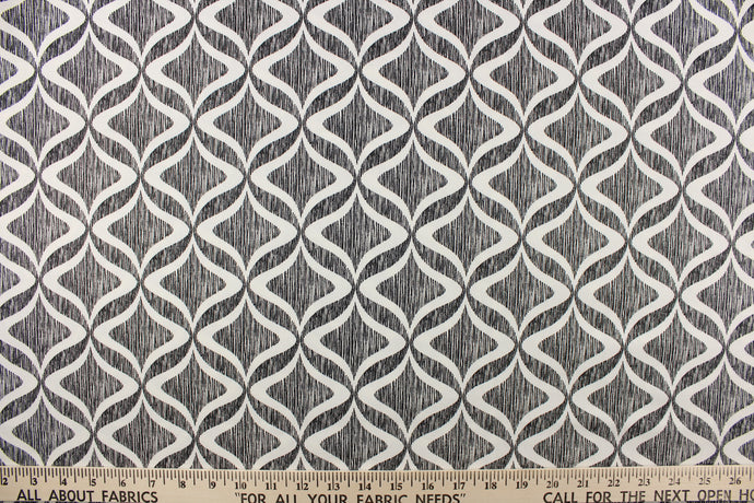 This fabric features a geometric design in white on against a thin black stripes.