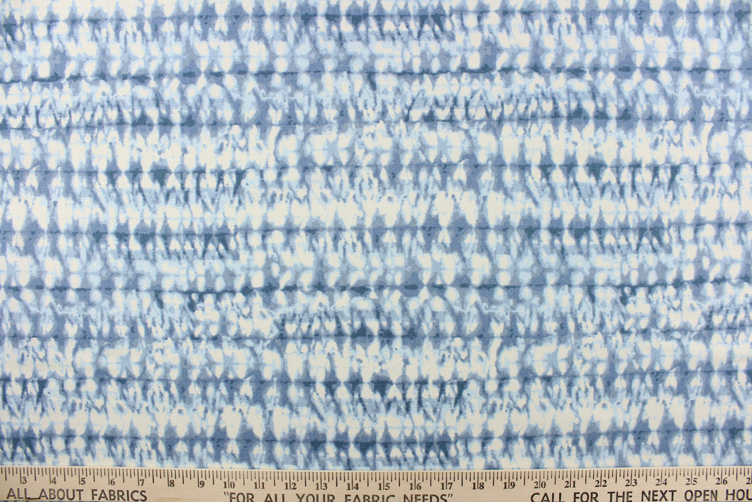  This fabric features an abstract design in varying shades of blue and white.