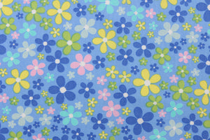 This cute cotton fabric features a floral design in varying shades of blue, with yellow, pink, green, and white against a blue background, 