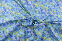 Load image into Gallery viewer, This cute cotton fabric features a floral design in varying shades of blue, with yellow, pink, green, and white against a blue background, 
