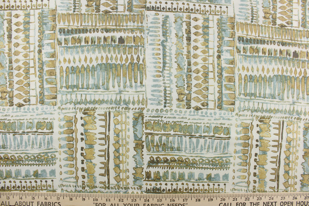 This fabric features an abstract design in blue green tones with tan and brown shades against a off white background. 