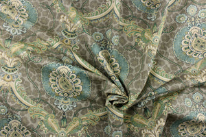 This unique fabric feature a medallion in varying shades of green, and  blue, with hints cream, gold and khaki against a taupe cheetah print. 