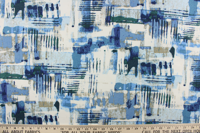 This outdoor fabric features an abstract design in varying shades of blue with white, green, and beige with hints of gray.