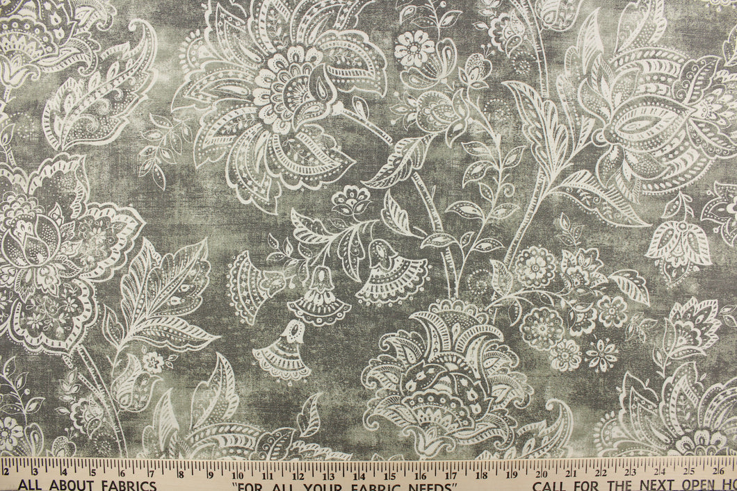 This fabric features a whimsical floral design in a off white against a gray with green undertones.