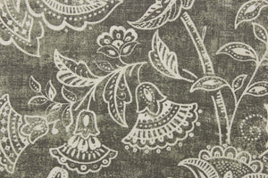 This fabric features a whimsical floral design in a off white against a gray with green undertones.
