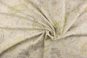 This fabric features a paisley vine design in a pale lime green and gray on a natural background. 