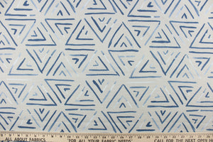  This fabric features a geometric design of triangles in a blue jean blue color with hints of white against gray.