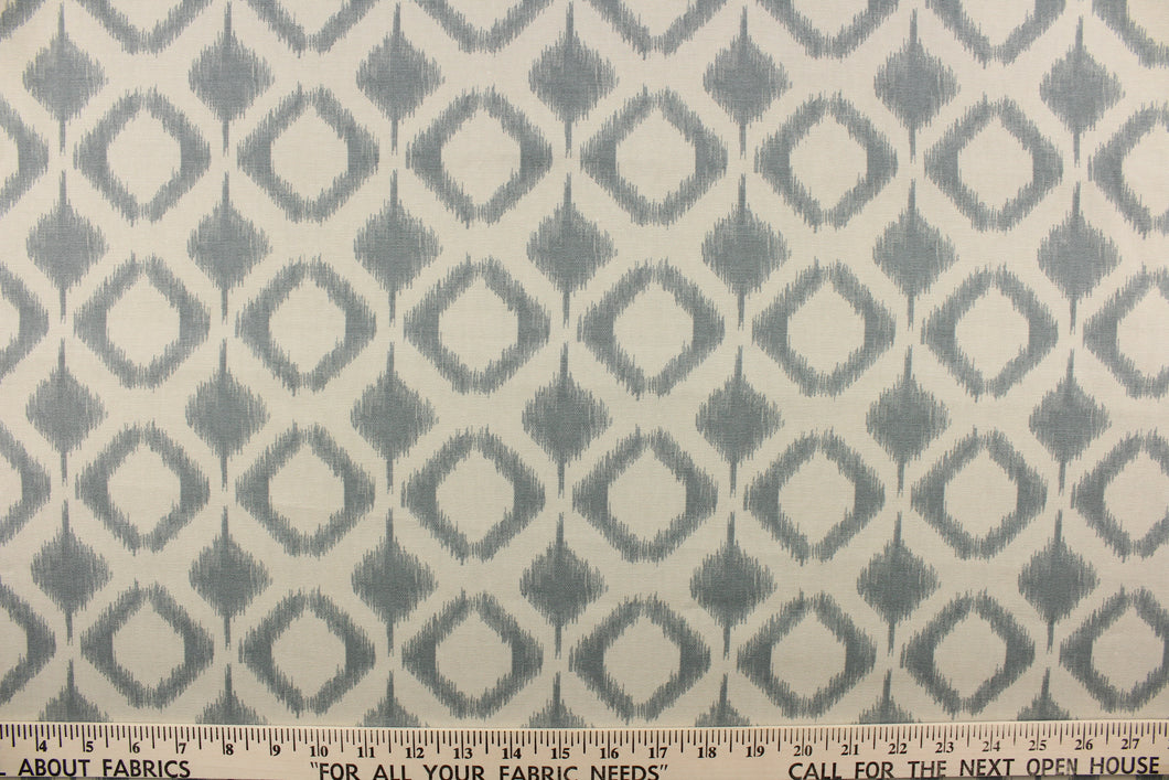 This fabric features a geometric design in diamond shapes in a blue gray tone against a off white background. 