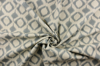 This fabric features a geometric design in diamond shapes in a blue gray tone against a off white background. 