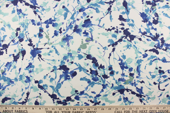 This fabric features a abstract design of paint blot/paint streaks in varying shades of blue or blue green on a white background.