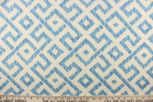  This fabric features a geometric design in blue and natural or off white