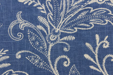 Load image into Gallery viewer, This fabric features a floral design in off white against a denim blue background.
