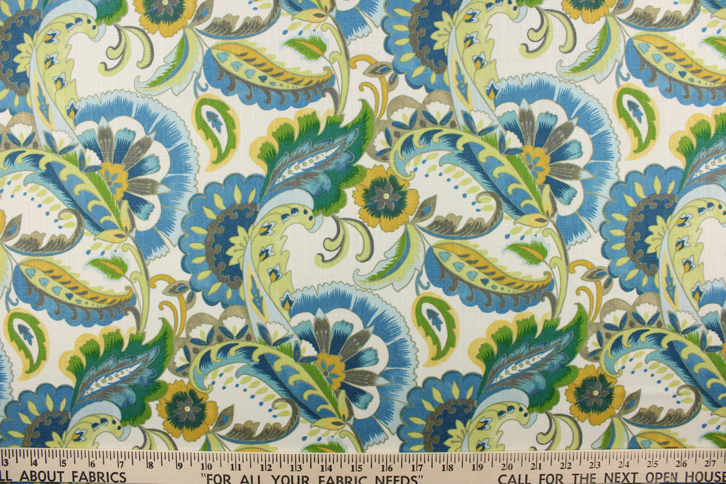 This fabric features a floral paisley design in shades of green, yellow, and blue with hints of gray and beige against a white background. 