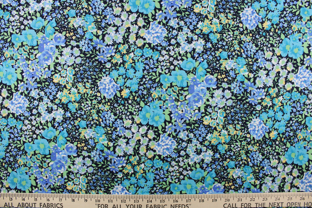 This quilting print features a floral design in varying shades of blue, teal, and yellow, green with hints of white against a black background. 