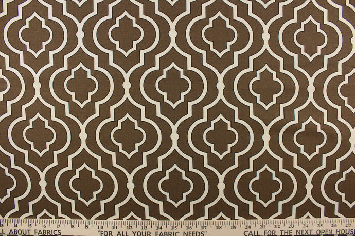This fabric features a geometric design in white with black outline against a brown background.