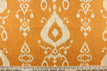 Load image into Gallery viewer, This fabric features an ikat design in a  yellow orange and off white. 
