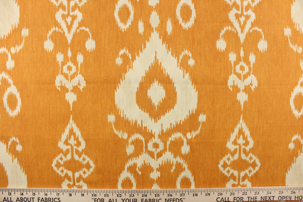This fabric features an ikat design in a  yellow orange and off white. 