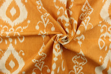 Load image into Gallery viewer, This fabric features an ikat design in a  yellow orange and off white. 
