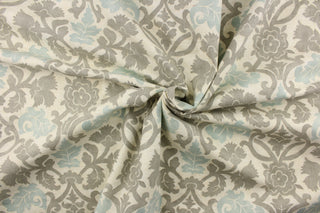 This fabric features a floral vine design in gray and pale blue against a off white background.
