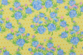  This quilting print features a beautiful rose design in blue, green, and pink against a light yellow background with dark yellow dots. 