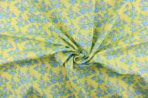  This quilting print features a beautiful rose design in blue, green, and pink against a light yellow background with dark yellow dots. 