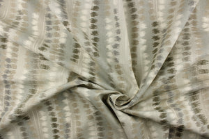  This fabric features an abstract design in gray, off white, and beige. 