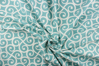 This fabric feature a delightful design of swirled lines that touch sides in white on a light teal background.