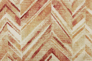  This fabric features a chevron design in shades of red, orange, pale khaki and white .