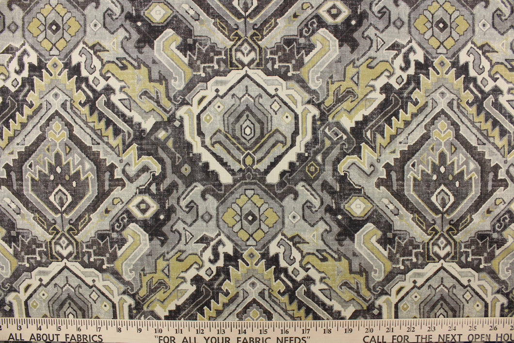This fabric features an Aztec design in mute gold, shades of gray, and off white with hints of black. 
