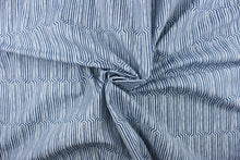 Load image into Gallery viewer, This fabric features a geometric design in a dull white against a denim blue. 
