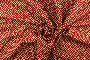 This fabric features a geometric design in beige against a deep red.