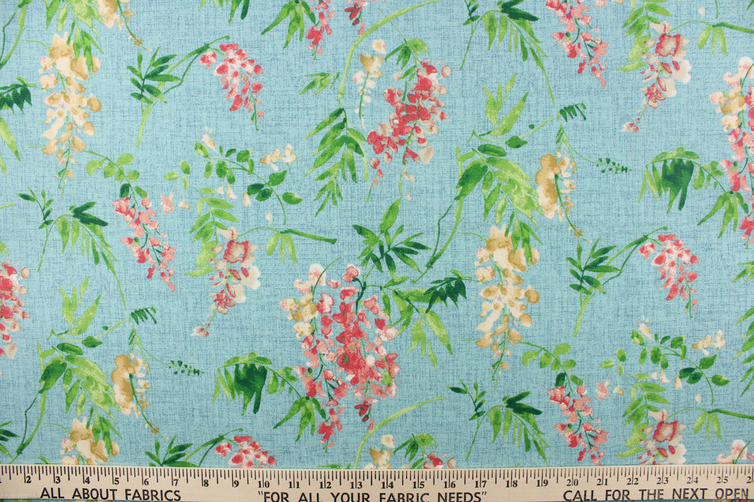 This fabric features a floral design in green, pink, beige, and white against a blue background.