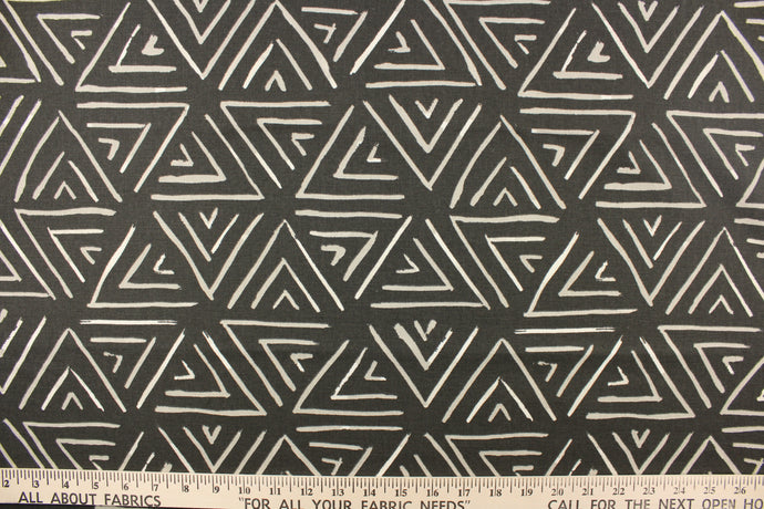 This fabric features a geometric design of triangles in a light gray and white against a dark charcoal gray