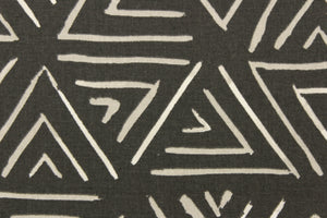 This fabric features a geometric design of triangles in a light gray and white against a dark charcoal gray