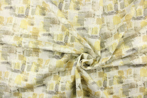 This fabric features an abstract design in golden yellow, gray, taupe, olive green, and off white . 