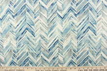 Load image into Gallery viewer, This fabric features a chevron design in shades of blue and gray and white. 
