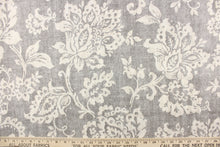 Load image into Gallery viewer, This fabric features a floral design in a dull white against a gray background.
