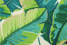 Load image into Gallery viewer, This indoor/outdoor fabric features tropical palm leaves set against a solid background and is perfect for any project where the fabric will be exposed to the weather. Colors include white, beige, opal and shades of green.
