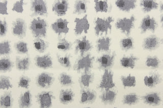 This screen printed fabric features ink blot shapes in shades of gray on a off white background.