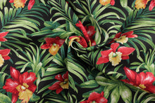 Load image into Gallery viewer, This polyester printed fabric has tropical red and yellow flowers with large green leaves on a black background and is perfect for any project where the fabric will be exposed to the weather. 
