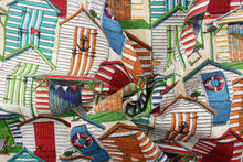 Load image into Gallery viewer, This fabric features small multi color beach huts nestled together near the ocean. Colors include orange, turquoise, green, yellow, tan and white.
