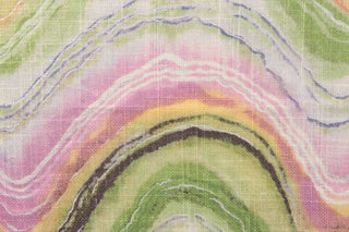 This screen printed fabric features abstract waves in shades of green, yellow, pink, purple, white and brown with metallic silver accents. 