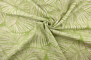 This pattern features large tropical leaves in lime green on a natural linen background. 
