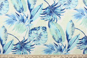  This outdoor fabric features a floral design in blue, pale green, and  turquoise against a white background. 