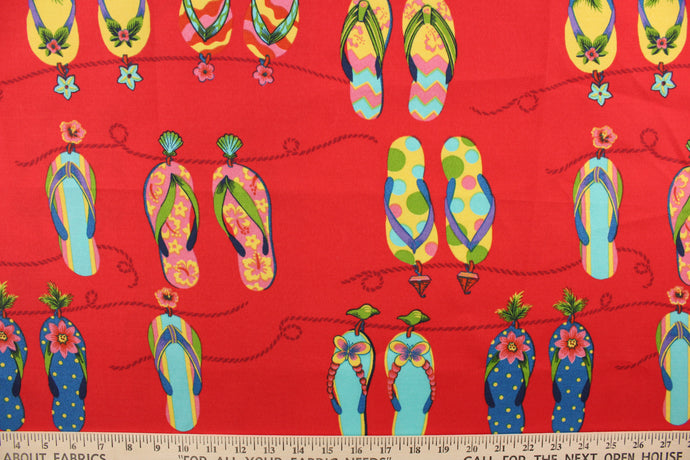 This outdoor fabric features brightly colored flipflops in yellow, pink, green, blue, and turquoise against red background. 