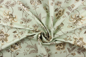  This fabric features a beautiful floral vine design in brown, khaki, and whites against a pale green background.